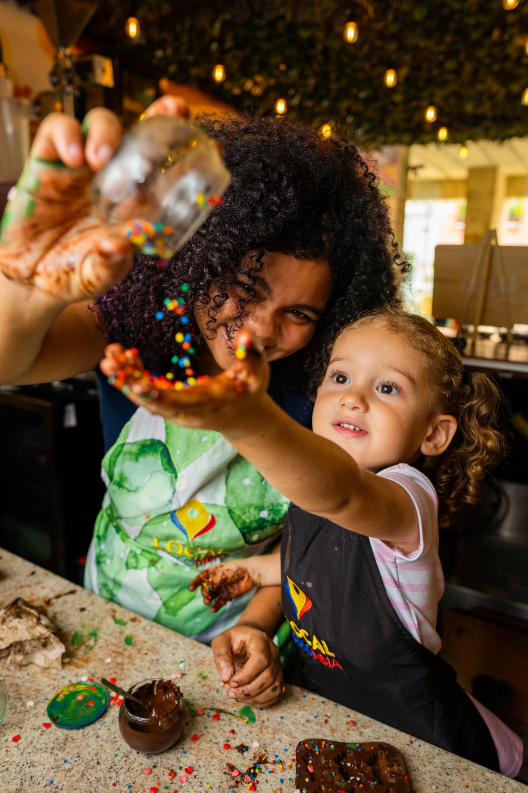 "Mother and child decorating chocolates during a chocolate workshop in Cartagena Colombia"